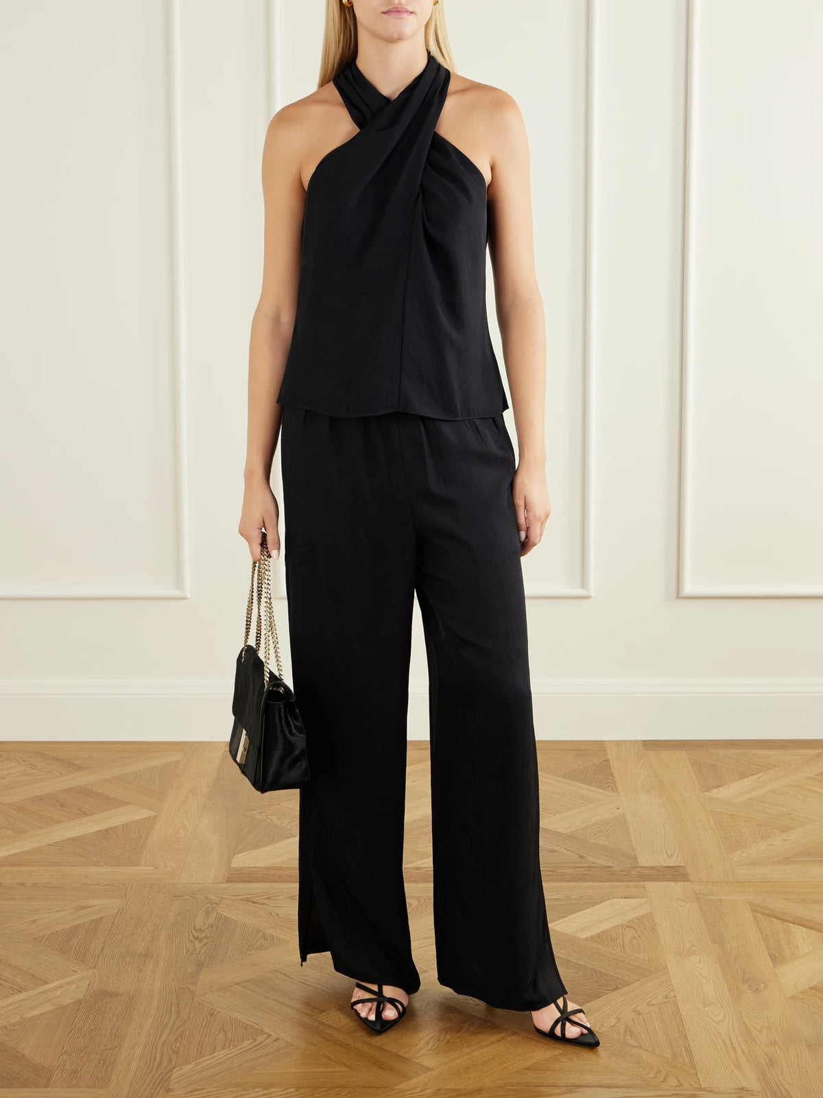 Image of a model wearing Tops. Product name - Crepe Halterneck Top in Black colour by brand - Theory