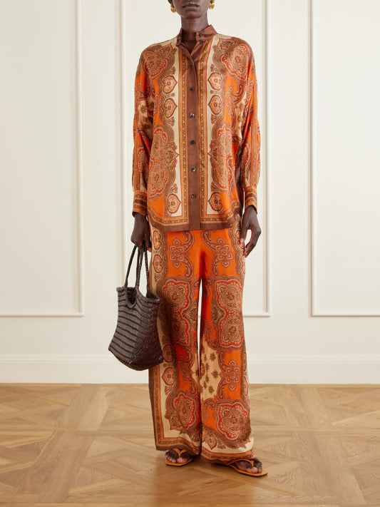 Image of a model wearing Pants. Product name - Mahon Printed Silk-satin Wide-leg Pants in Brown colour by brand - Zimmermann
