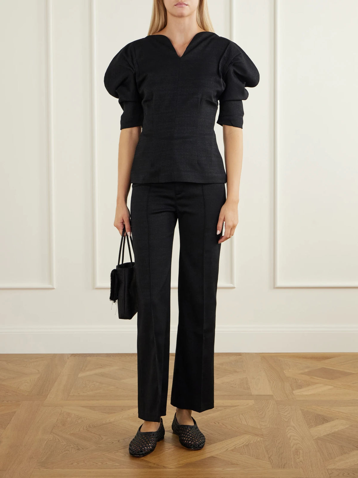 Image of a model wearing Pants. Product name - Yoshitomo Drill Wide-leg Pants in Black colour by brand - DESTREE