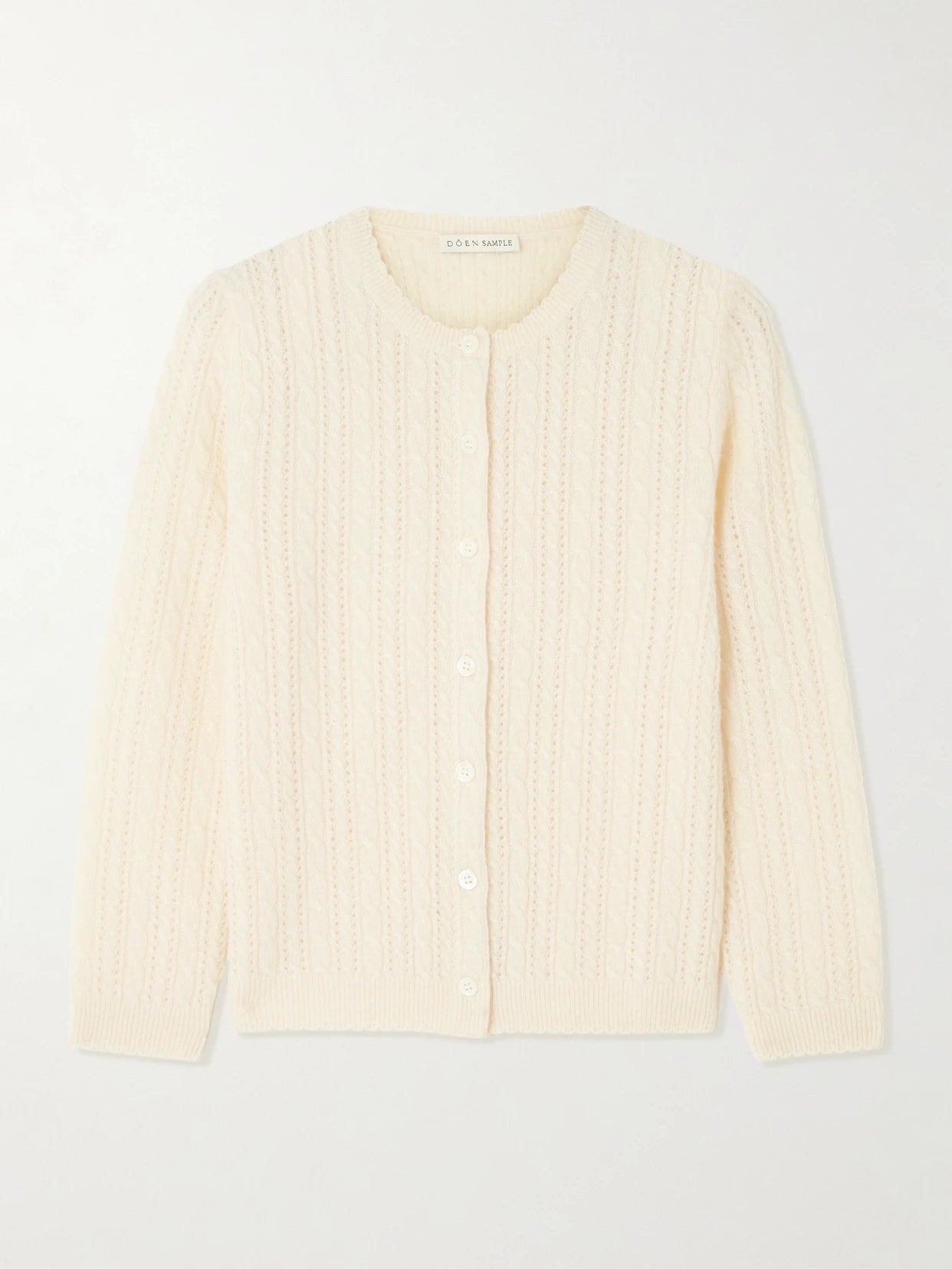 Image of a model wearing Outerwear. Product name - Danae Cropped Cable-knit Cashmere Cardigan in Cream colour by brand - DÔEN