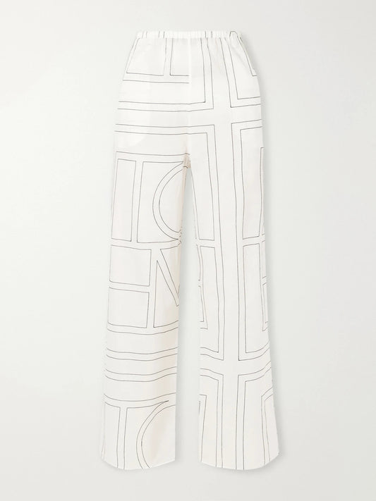 Image of a model wearing Pants. Product name - Embroidered Organic Cotton And Lyocell-blend Wide-leg Pants in White colour by brand - TOTEME