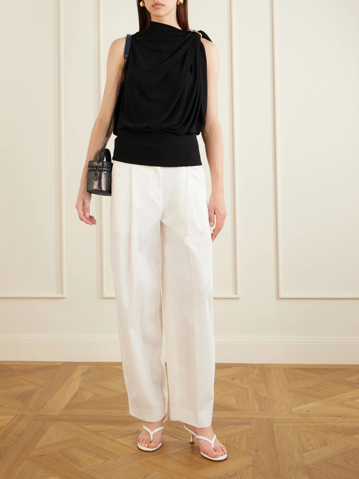 Image of a model wearing Pants. Product name - Pleated Cotton Wide-leg Trousers in White colour by brand - TOTEME