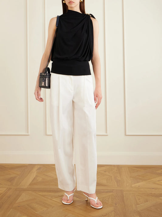 Image of a model wearing Pants. Product name - Pleated Cotton Wide-leg Trousers in White colour by brand - TOTEME