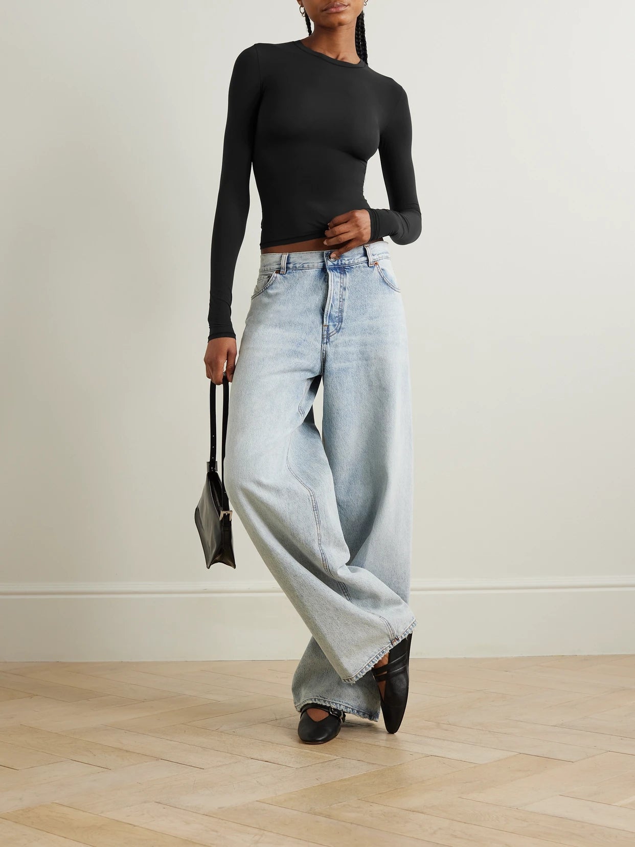 Image of a model wearing Tops. Product name - Fits Everybody Long Sleeve T-shirt - Onyx in Black colour by brand - SKIMS