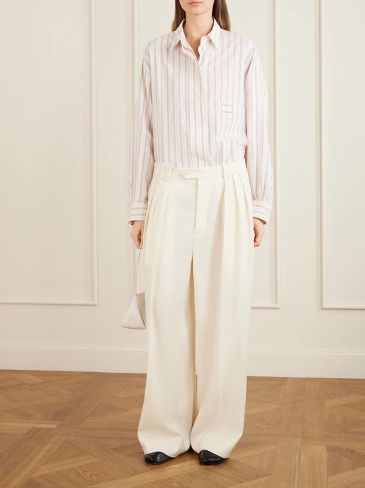 Image of a model wearing Pants. Product name - Alexandra Pleated Grain De Poudre Wool Wide-leg Pants in Ivory colour by brand - Calvin Klein Collection