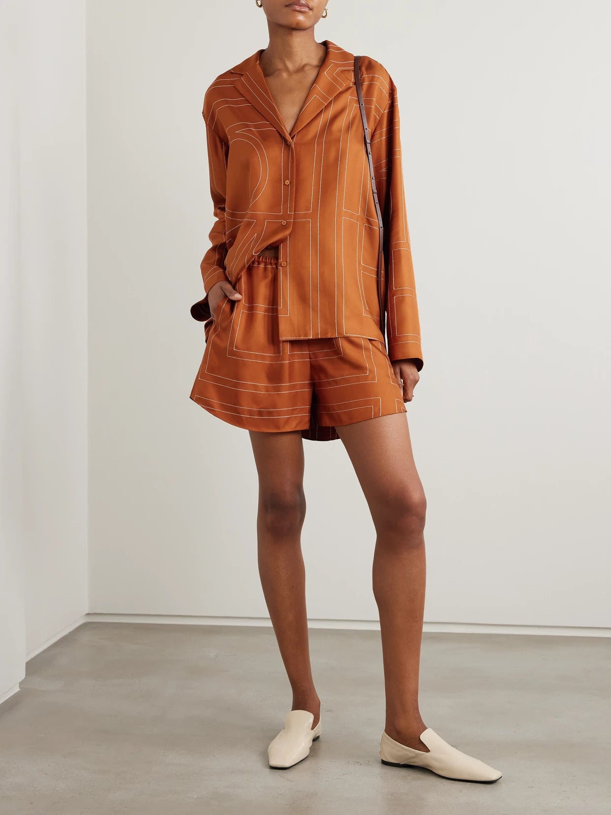 Image of a model wearing Shorts. Product name - Embroidered Silk-twill Shorts in Orange colour by brand - TOTEME