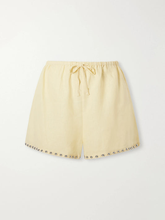 Image of a model wearing Shorts. Product name - Paddle Studded Linen Shorts in Pastel yellow colour by brand - STAUD