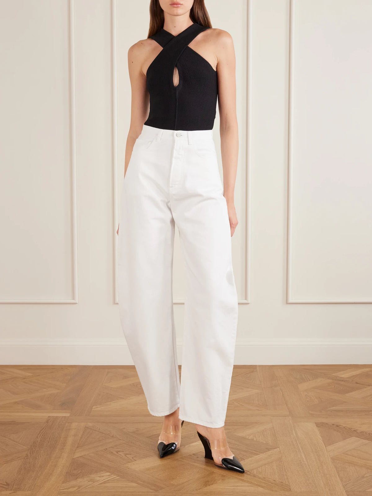 Image of a model wearing Tops. Product name - Cross Body Compact Bodysuit in Black colour by brand - Alaïa