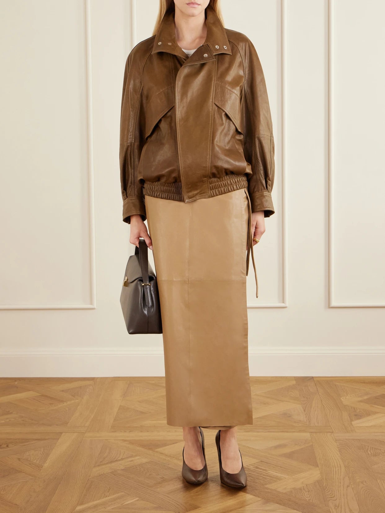 Image of a model wearing Skirts. Product name - Paneled Leather Maxi Wrap Skirt in Camel colour by brand - Nour Hammour