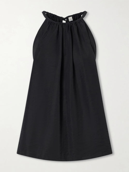 Image of a model wearing Tops. Product name - Gathered Lyocell-blend Halterneck Top in Black colour by brand - TOTEME