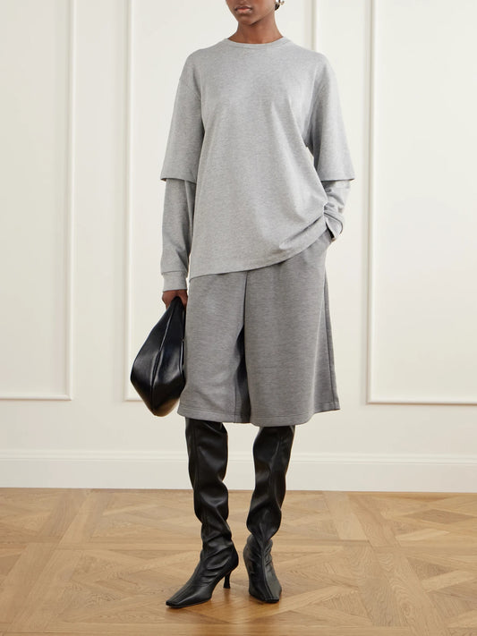 Image of a model wearing Shorts. Product name - Feather Weight Jersey Shorts in Gray colour by brand - Tibi
