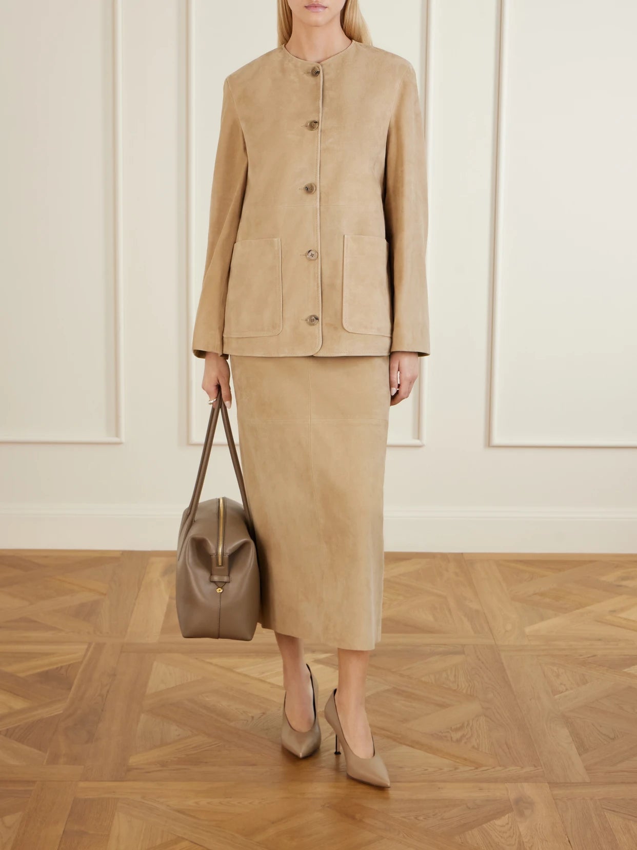Image of a model wearing Skirts. Product name - Selly Suede Midi Skirt in Sand colour by brand - Nour Hammour