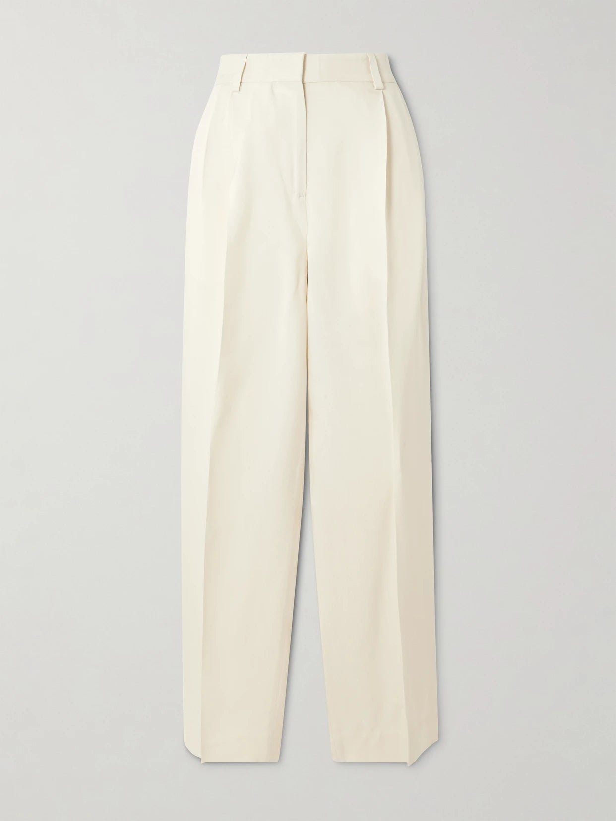 Image of a model wearing Pants. Product name - Garderob Pleated Woven Tapered Pants in Ecru colour by brand - TOTEME