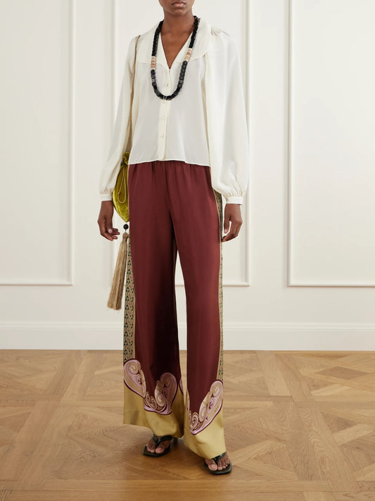 Image of a model wearing Pants. Product name - Palazzo Printed Silk-twill Wide-leg Pants in Burgundy colour by brand - La DoubleJ
