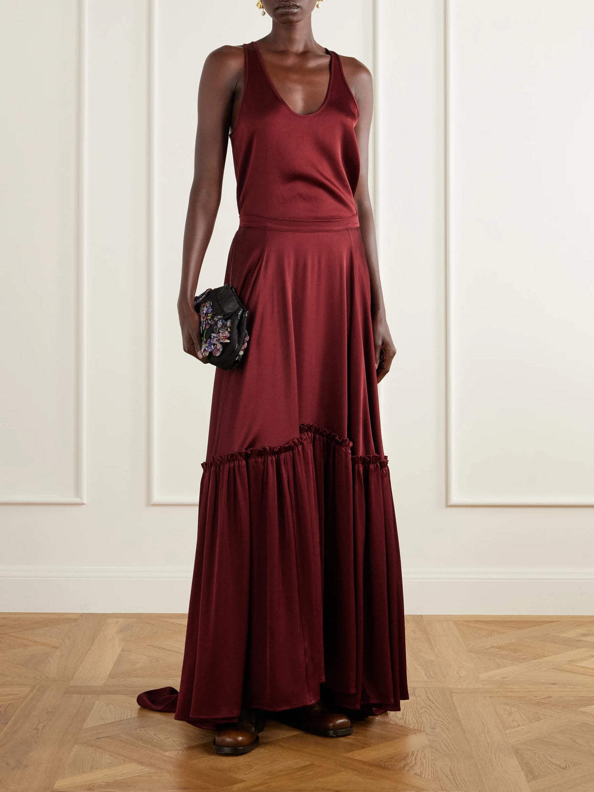 Image of a model wearing Skirts. Product name - The Margot Ruffled Tiered Satin Maxi Skirt in Burgundy colour by brand - Giuliva Heritage