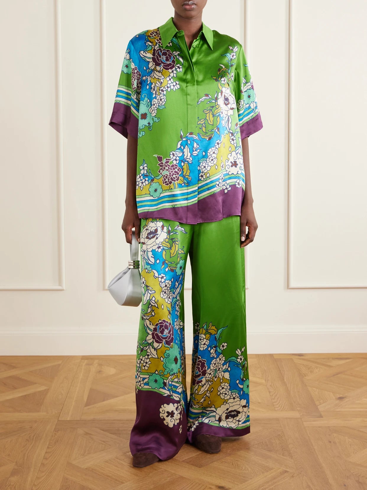 Image of a model wearing Pants. Product name - Nanci Floral-print Silk-satn Wide-leg Pants in Green colour by brand - ALÉMAIS