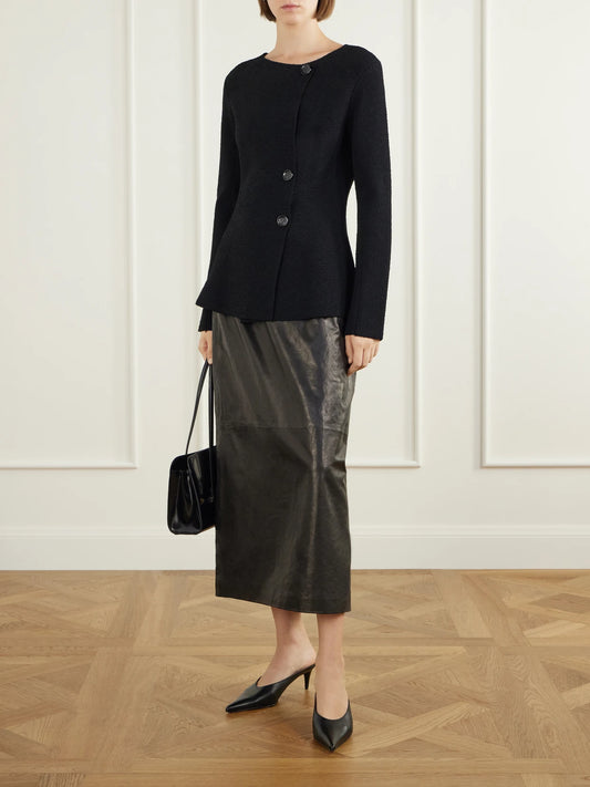 Image of a model wearing Skirts. Product name - Leather Midi Skirt in Black colour by brand - Magda Butrym