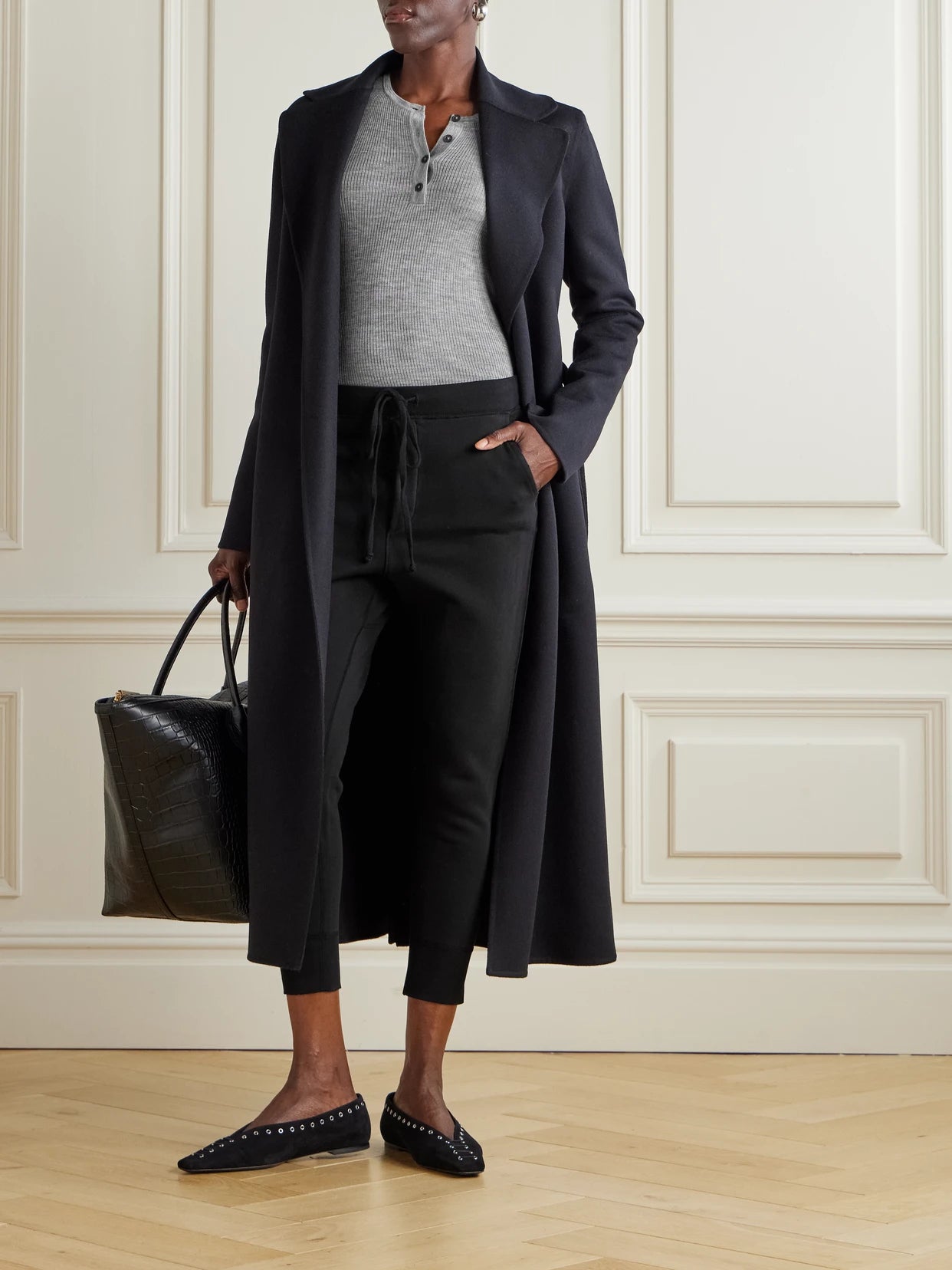 Image of a model wearing Pants. Product name - Nolan Cropped Cotton-jersey Track Pants in Black colour by brand - Nili Lotan