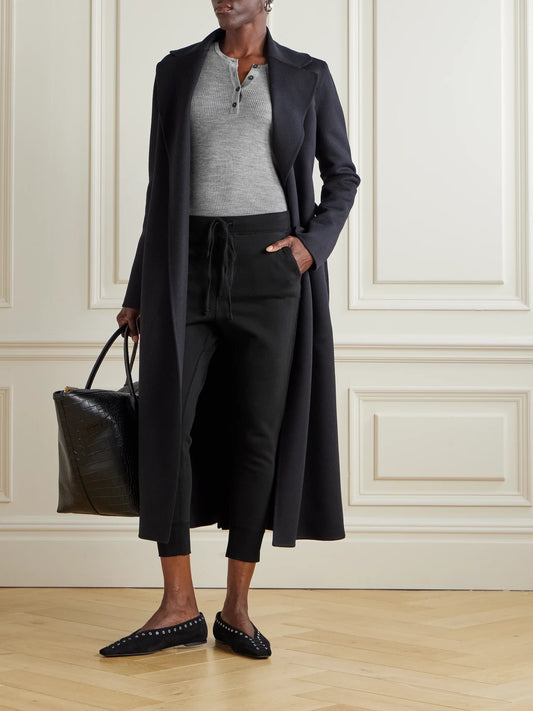 Image of a model wearing Pants. Product name - Nolan Cropped Cotton-jersey Track Pants in Black colour by brand - Nili Lotan