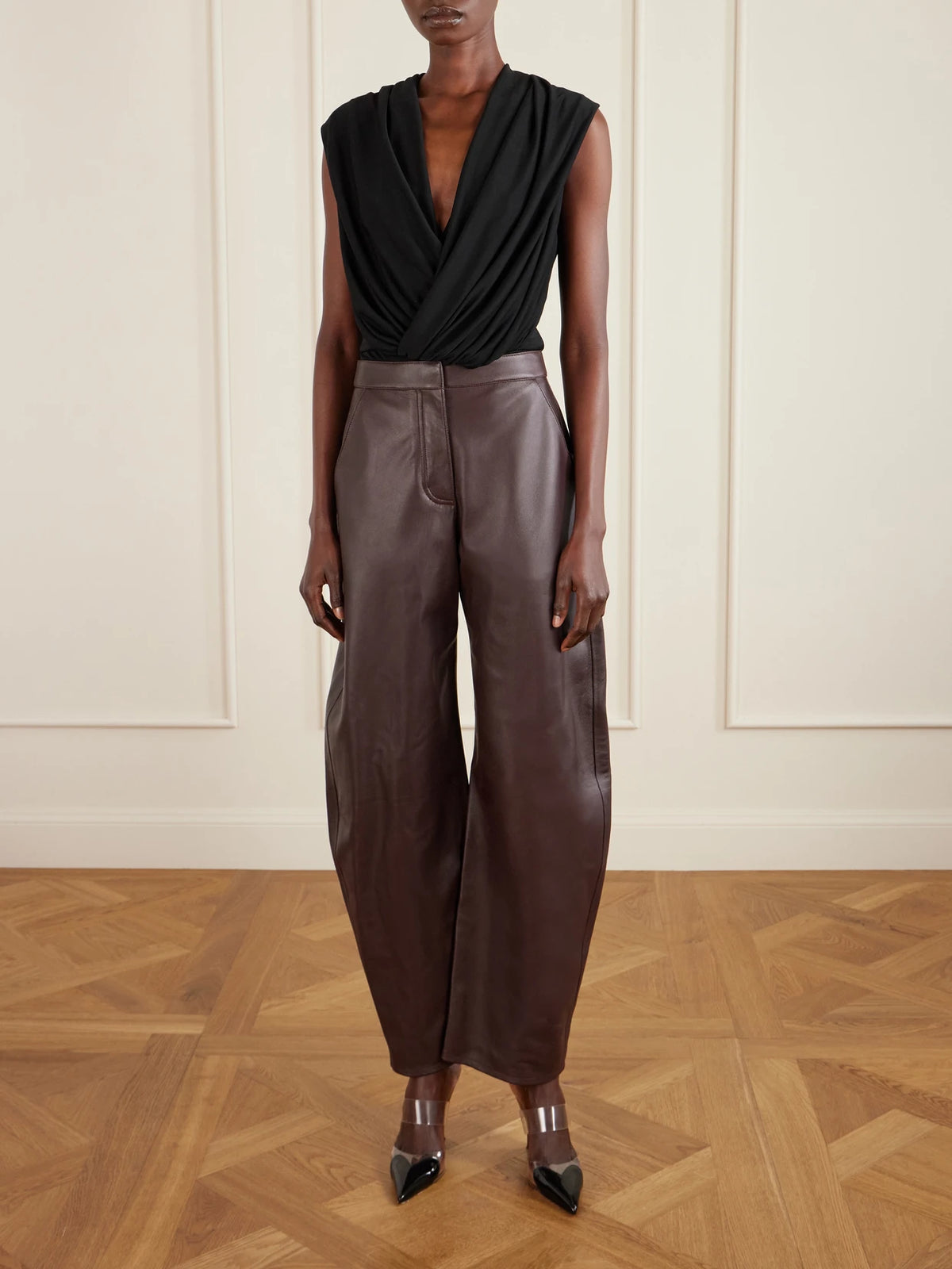 Image of a model wearing Tops. Product name - Hooded Draped Jersey Bodysuit in Black colour by brand - Alaïa