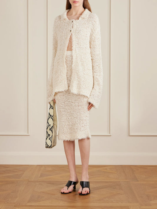 Image of a model wearing Skirts. Product name - Adela Bouclé Midi Skirt in Ivory colour by brand - KHAITE