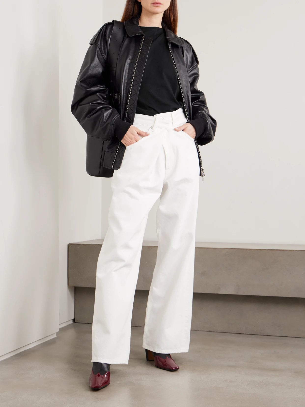 Image of a model wearing Tops. Product name - Beth Asymmetric Draped Cotton-jersey T-shirt in Black colour by brand - AGOLDE