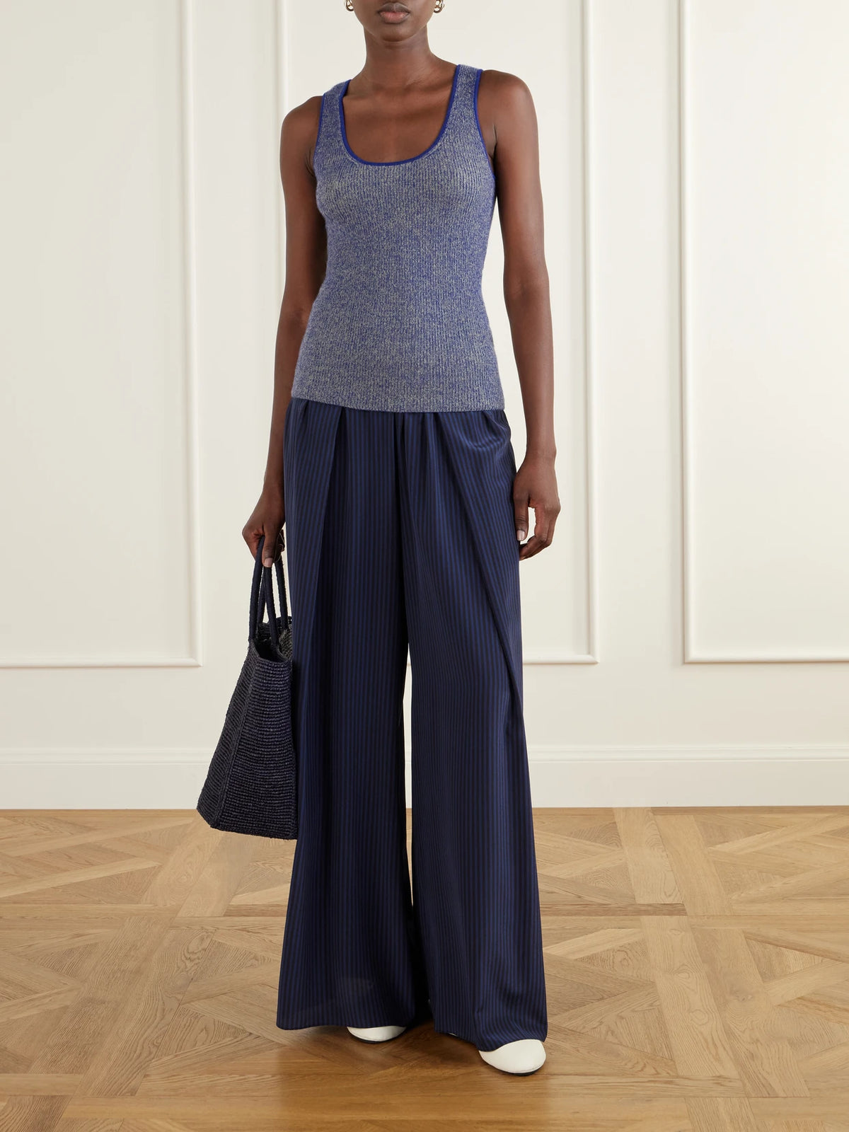 Image of a model wearing Pants. Product name - Striped Silk-satin Wide-leg Pants in Navy colour by brand - La Ligne