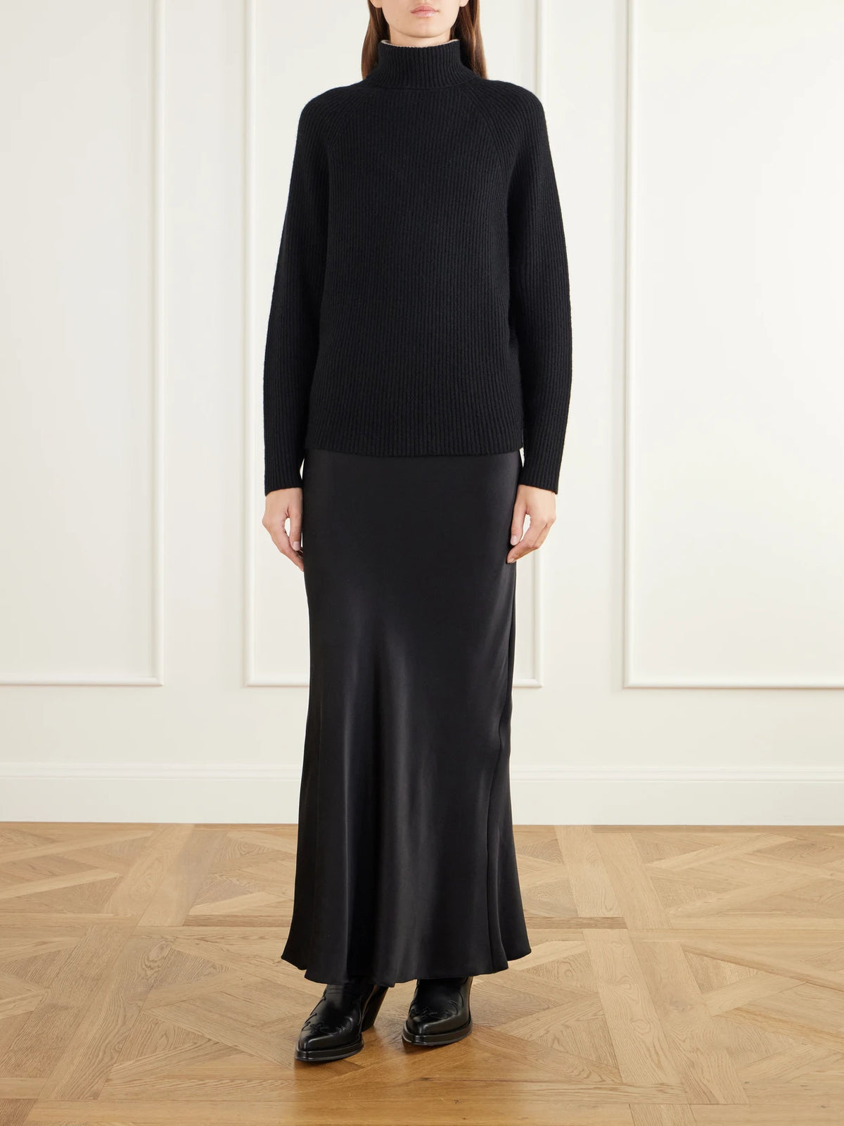 Image of a model wearing Outerwear. Product name - Wigman Ribbed Cashmere Turtleneck Sweater in Black colour by brand - Gabriela Hearst