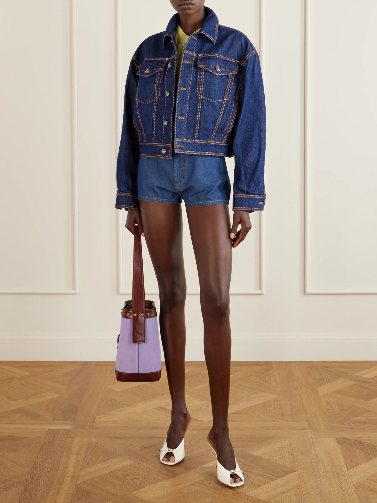 Image of a model wearing Shorts. Product name - Denim High-rise Shorts in Dark denim colour by brand - Versace