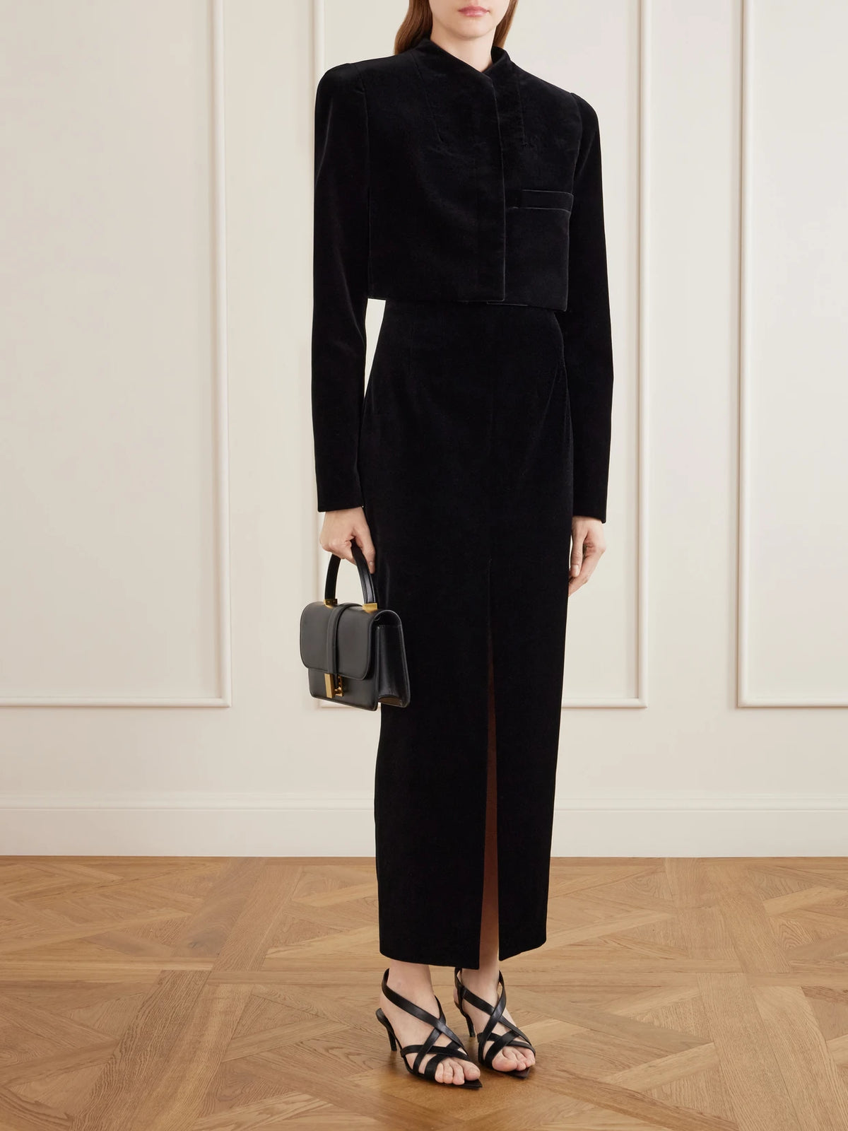 Image of a model wearing Skirts. Product name - Lachlan Velvet Cotton-blend Midi Skirt in Black colour by brand - KHAITE