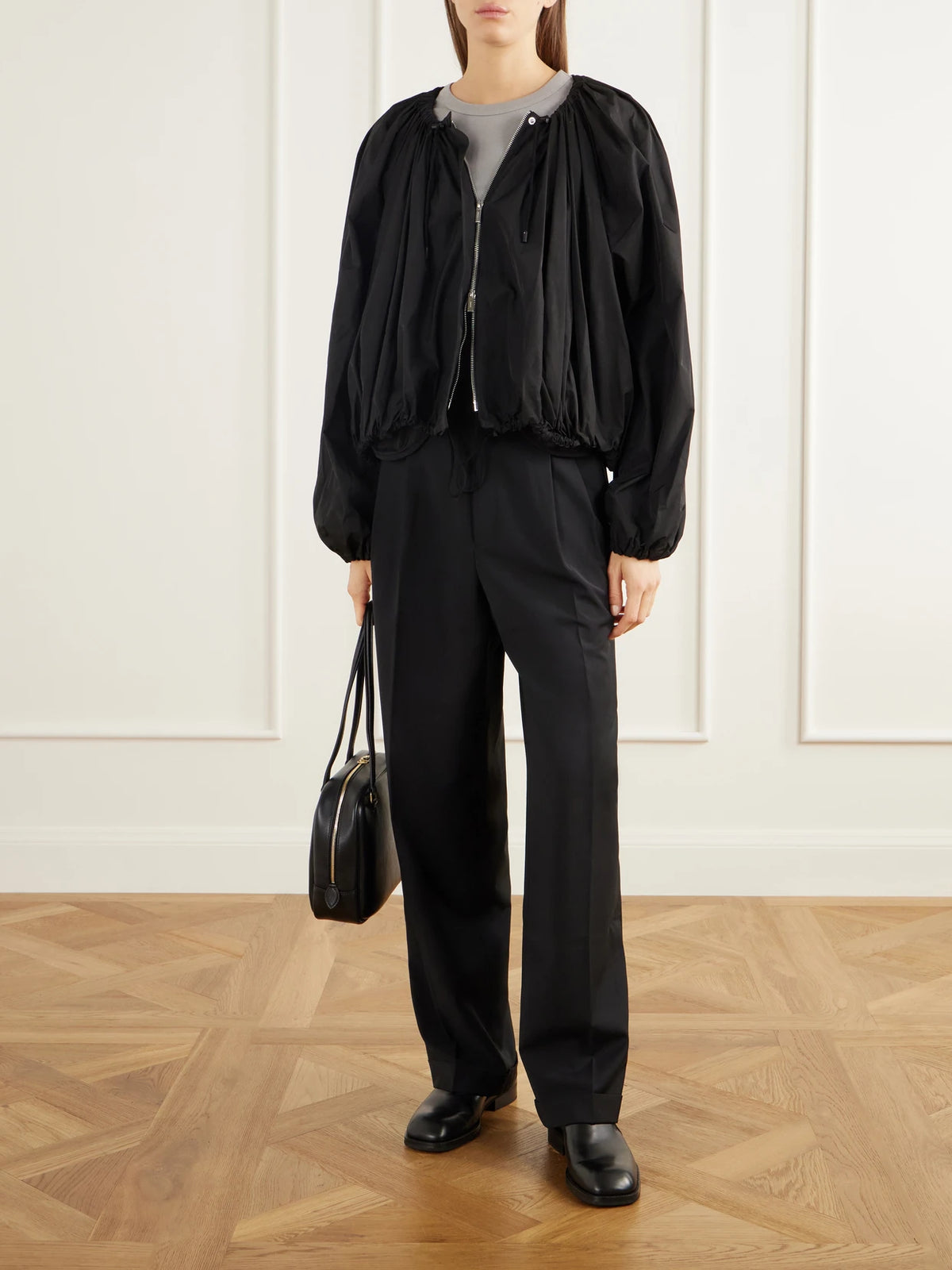 Image of a model wearing Pants. Product name - Mesh-trimmed Pleated Fresco Straight-leg Pants in Black colour by brand - Tibi