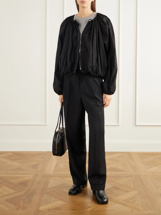 Image of a model wearing Pants. Product name - Mesh-trimmed Pleated Fresco Straight-leg Pants in Black colour by brand - Tibi