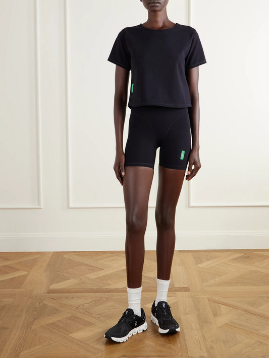 Image of a model wearing Shorts. Product name - Logo-appliquéd 5'' Stretch-knit Shorts in Black colour by brand - District Vision