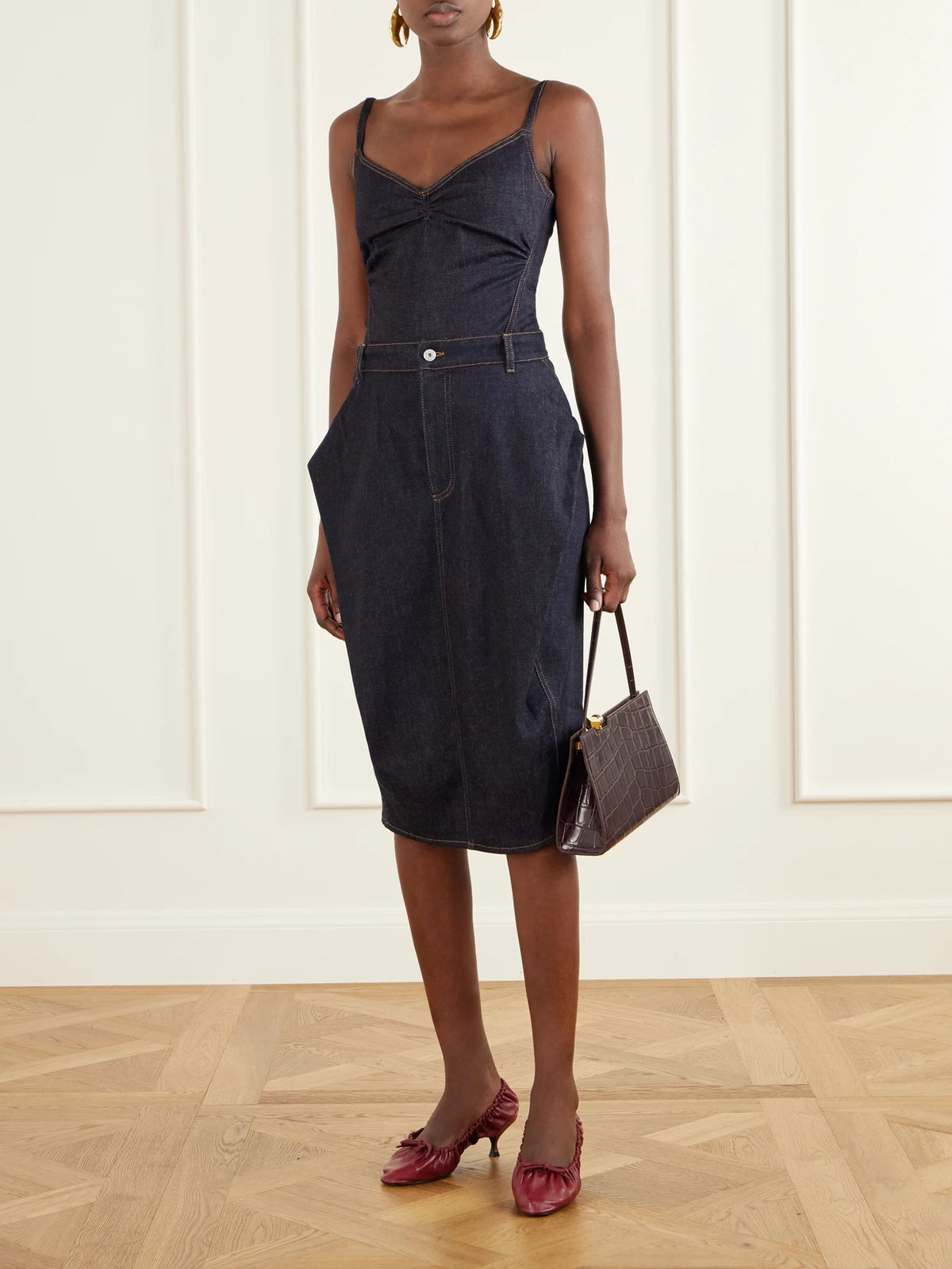 Image of a model wearing Skirts. Product name - Cubisto De Nimes Cotton-blend Denim Midi Skirt in Navy colour by brand - Jacquemus