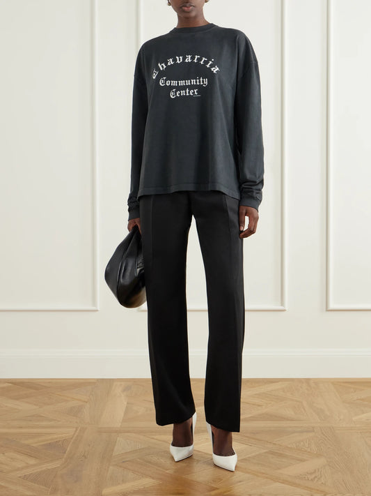 Image of a model wearing Pants. Product name - Pleated Wool-blend High-rise Straight-leg Pants in Black colour by brand - Willy Chavarria