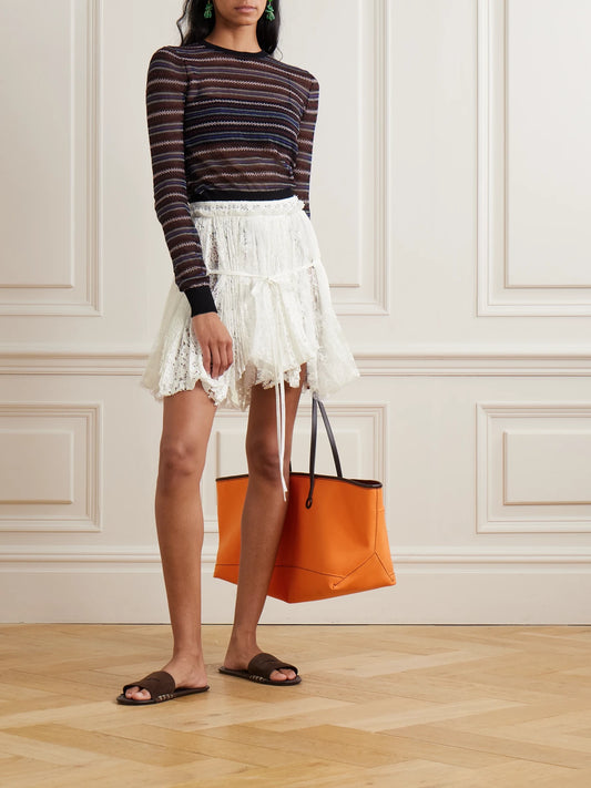 Image of a model wearing Skirts. Product name - Asymmetric Tie-detailed Lace Mini Skirt in White colour by brand - JW Anderson