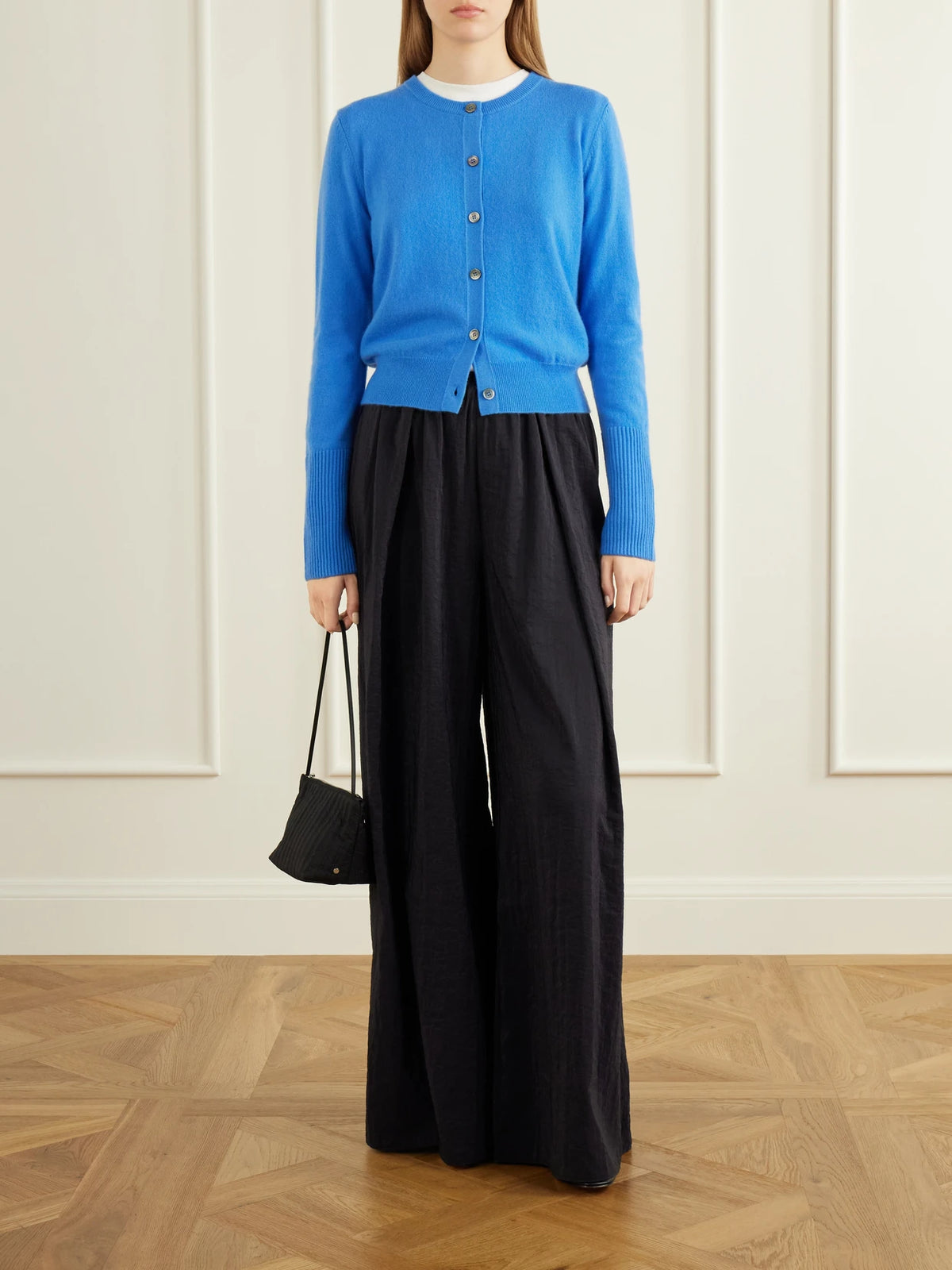 Image of a model wearing Pants. Product name - Pleated Crinkle Satin Wide-leg Pants in Black colour by brand - La Ligne