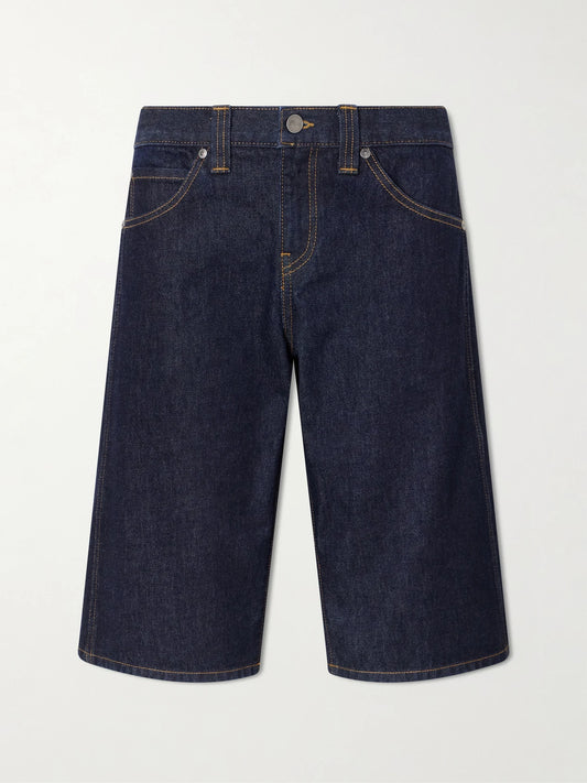 Image of a model wearing Shorts. Product name - Kinga Mid-rise Straight-leg Shorts in Dark denim colour by brand - KHAITE