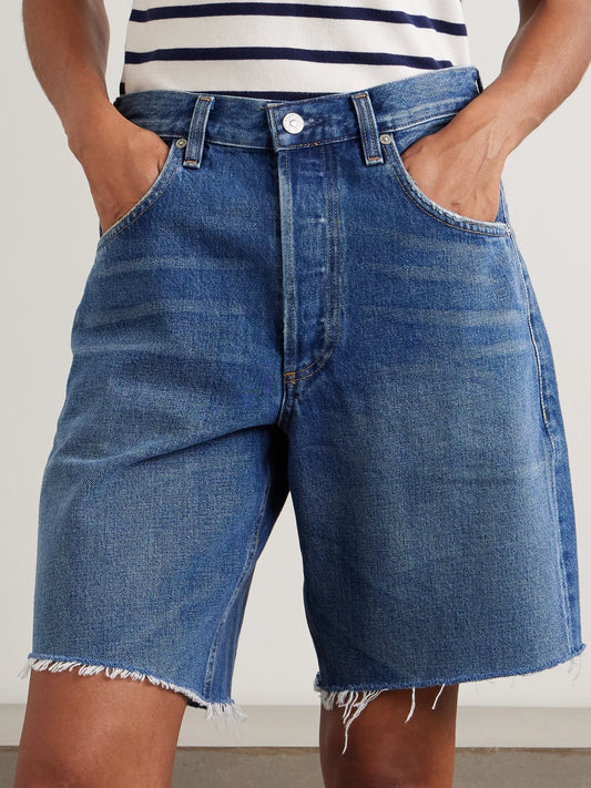 Image of a model wearing Shorts. Product name - Ayla Frayed Denim Shorts in Mid denim colour by brand - Citizens of Humanity