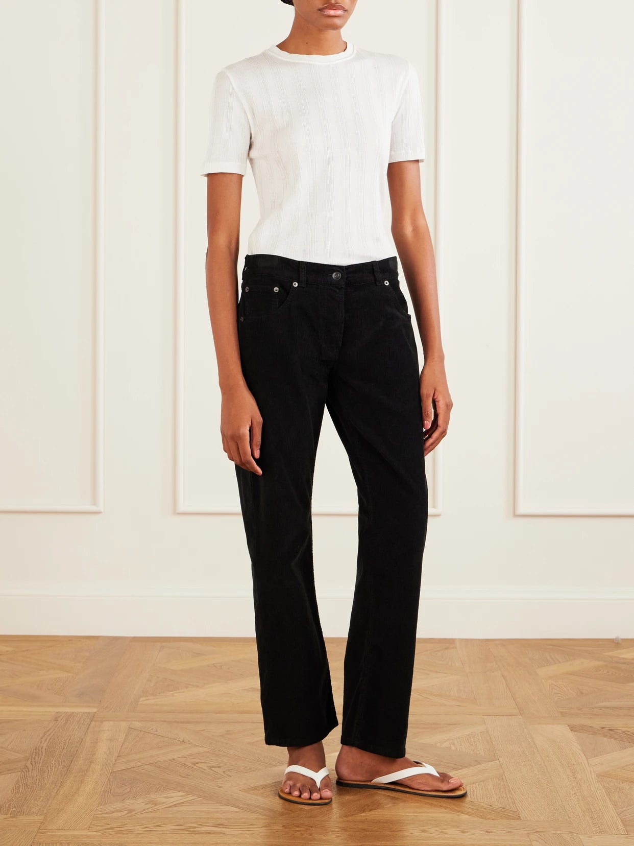 Image of a model wearing Pants. Product name - Fima Cotton-blend Corduroy Straight-leg Pants in Black colour by brand - The Row