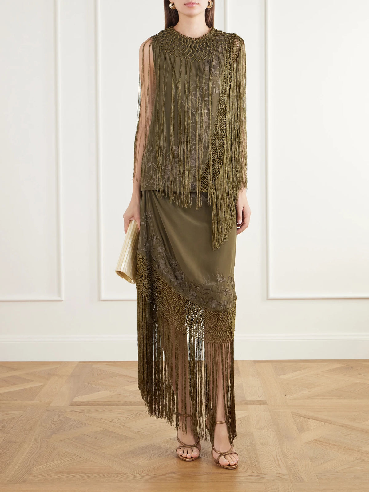 Image of a model wearing Skirts. Product name - Lark Fringed Embroidered Silk-crepe De Chin Midi Skirt in Army green, Ivory colour by brand - Ulla Johnson