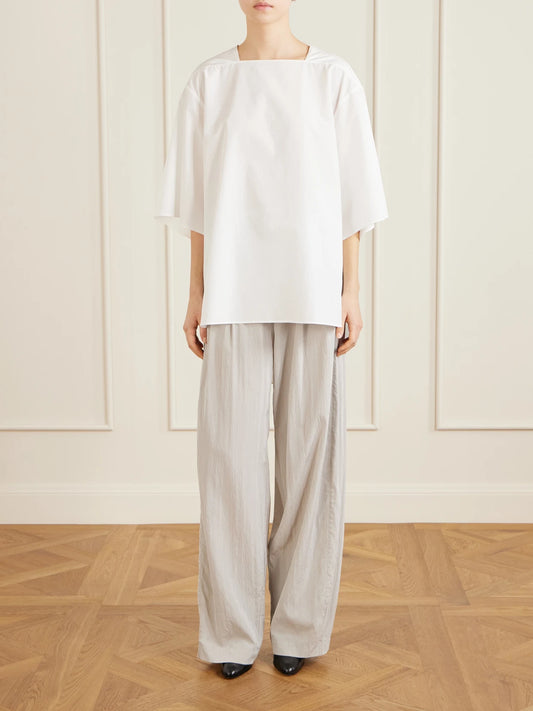 Image of a model wearing Tops. Product name - Hamza Oversized Cotton-poplin Top in White colour by brand - The Row