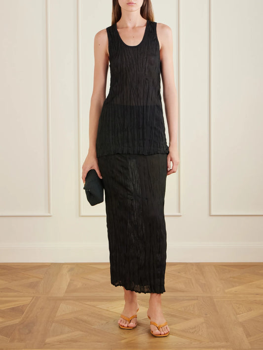 Image of a model wearing Skirts. Product name - Crinkled Knit Viscose Midi Skirt in Black colour by brand - TOTEME