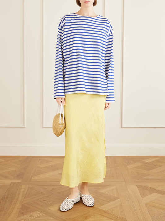 Image of a model wearing Skirts. Product name - Lyra Sunlight Silk Midi Skirt in Pastel yellow colour by brand - ALIX OF BOHEMIA