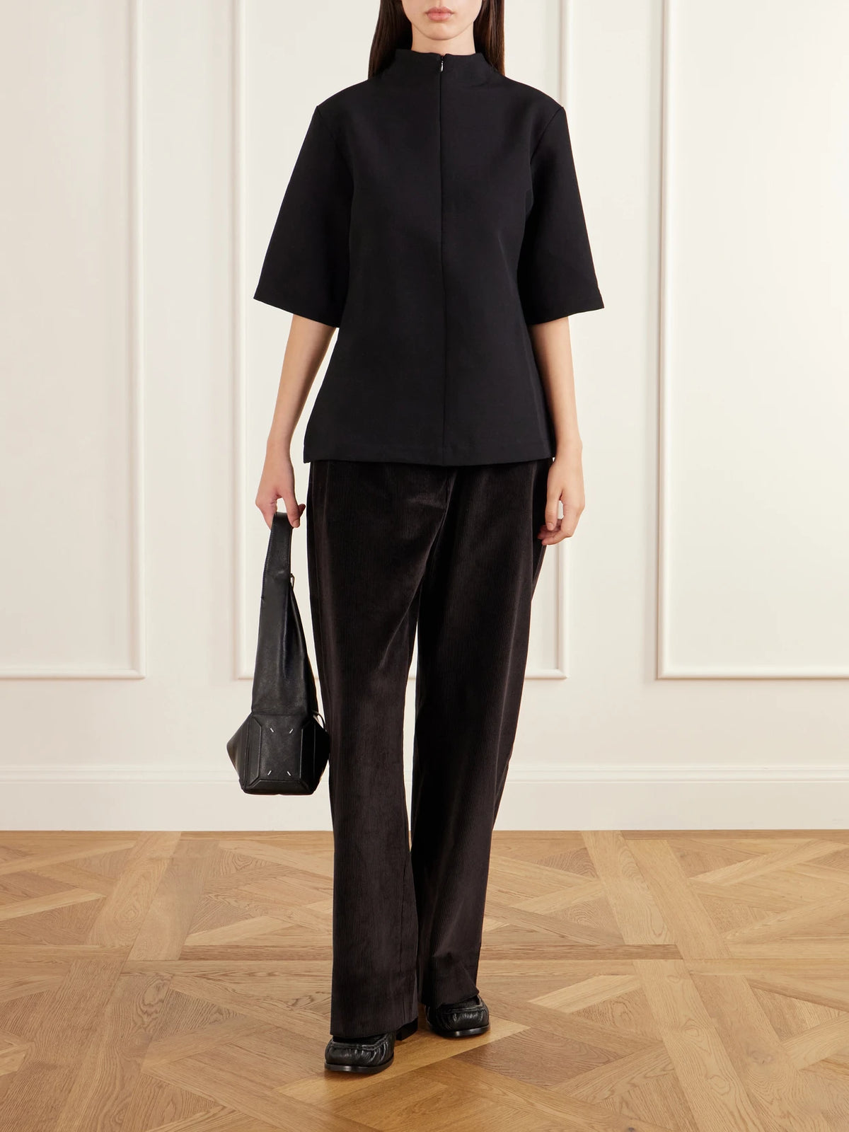 Image of a model wearing Tops. Product name - Taler Wool-blend Top in Black colour by brand - Studio Nicholson