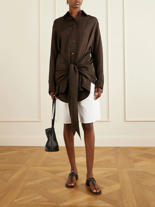 Image of a model wearing Tops. Product name - Arroyo Knotted Crinkled-satin Shirt in Brown colour by brand - OSSOU