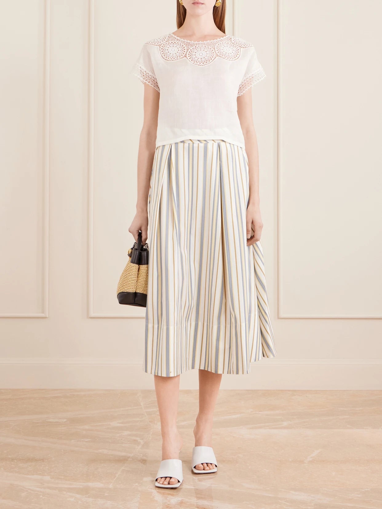 Image of a model wearing Skirts. Product name - Wynona Pleated Striped Cotton-gabardine Midi Skirt in Cream colour by brand - Thierry Colson