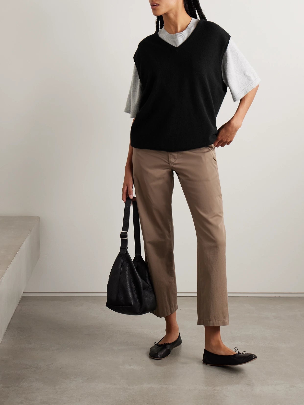 Image of a model wearing Outerwear. Product name - Kossy Cashmere Vest in Black colour by brand - The Row