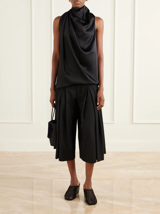 Image of a model wearing Shorts. Product name - Pleated Wool-fresco Culotte Shorts in Black colour by brand - LIBEROWE