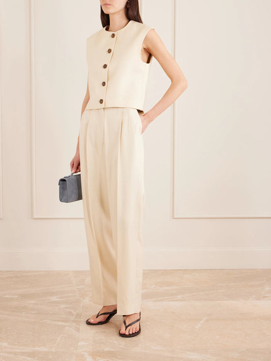 Image of a model wearing Pants. Product name - Danae Pleated Tapered Woven Pants in Beige colour by brand - BLAZÉ Milano